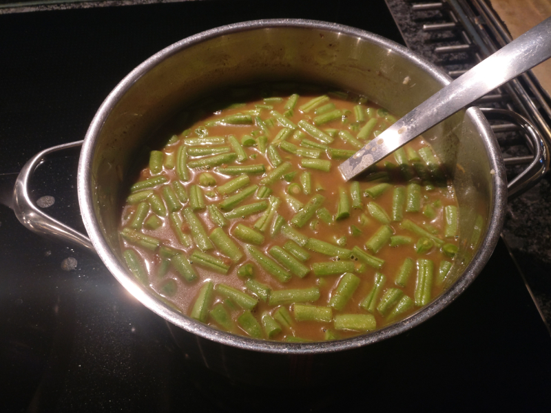 Sperziebonen in een pan met currysaus